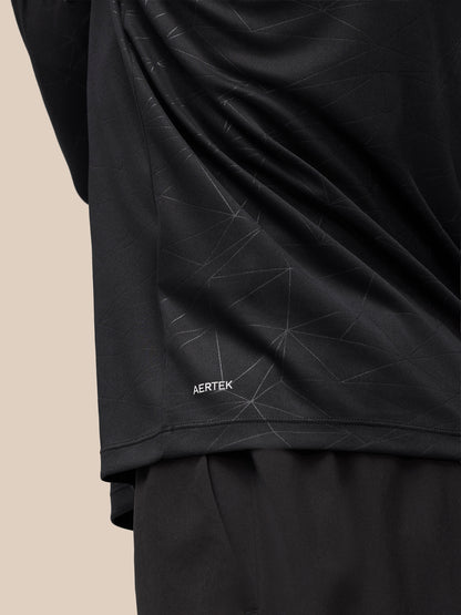 Back view highlighting geometric print and AerTek label near hem on the black Adapt Training Top