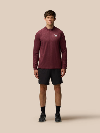 Front view of a man wearing plum Adapt Training 1/4 Zip Top with center front zip and Castore logo on the left chest