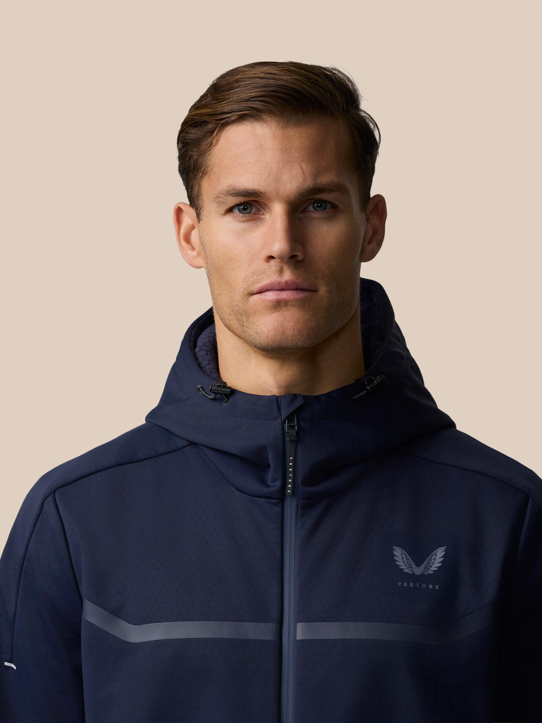 Front view of male model wearing navy Garcia 3.0 Hoodie with hood down and chest logo.