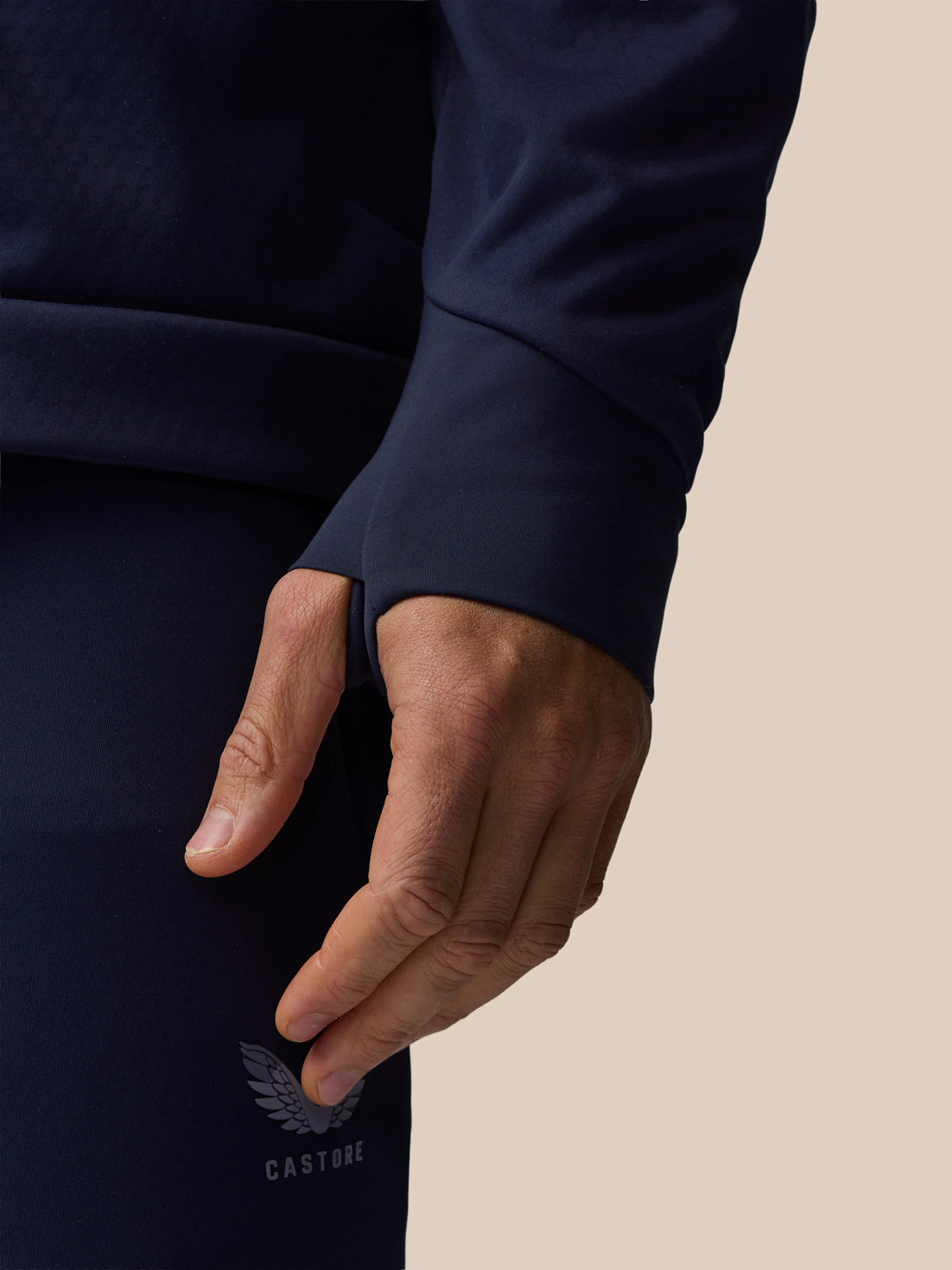 Close-up of navy Garcia 3.0 Hoodie sleeve cuff with textured fabric and Castore logo on pants.