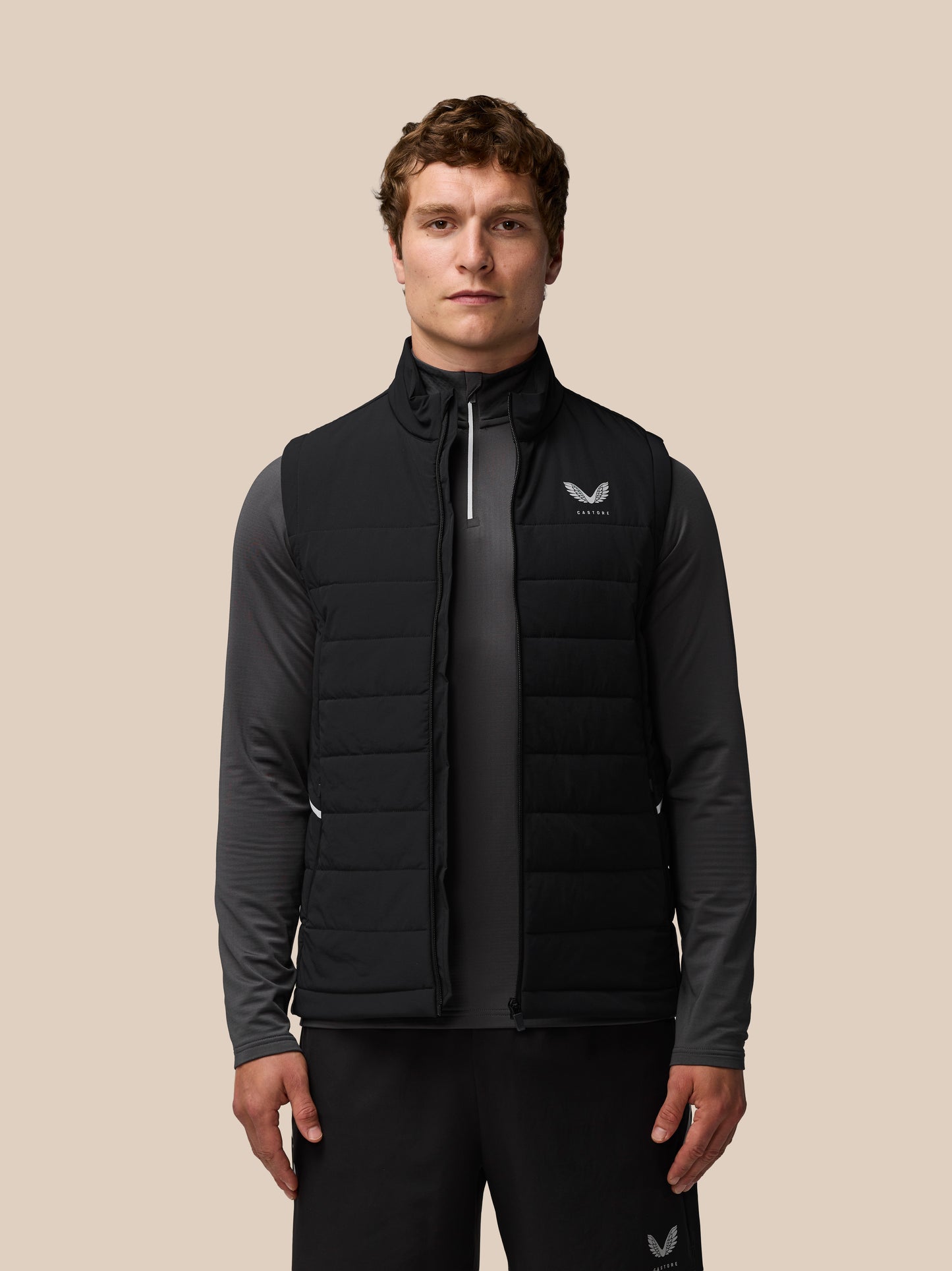 Front view of a man wearing a black Apex Training Gilet with Castore logo on the left chest