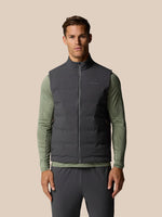Male model wearing Zone Training LVS Insulated Gilet in gunmetal over olive long sleeve, with front zipper and sleeveless design.