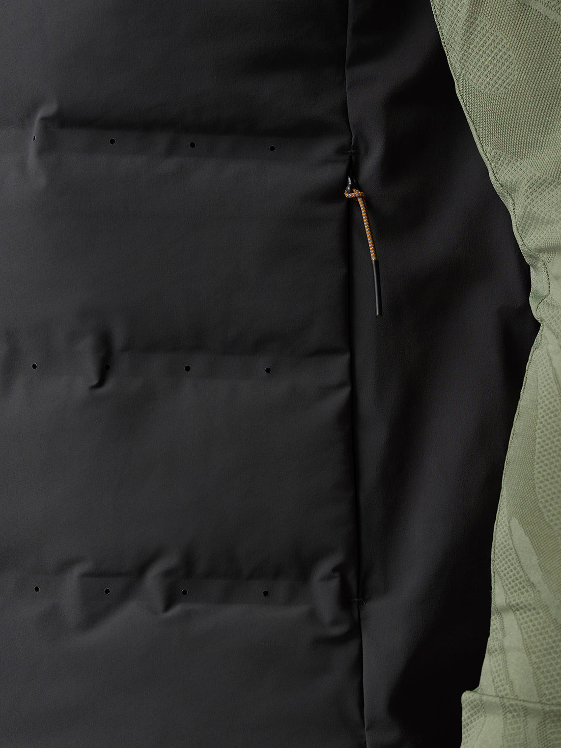 Close up of the gilet back showing a lower back zippered pocket and ventilation holes