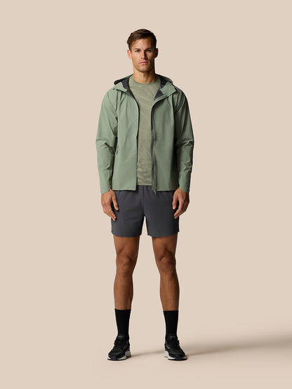 Male model wearing Zone Training LVS Jacket in Thyme with hood down and full zip front view