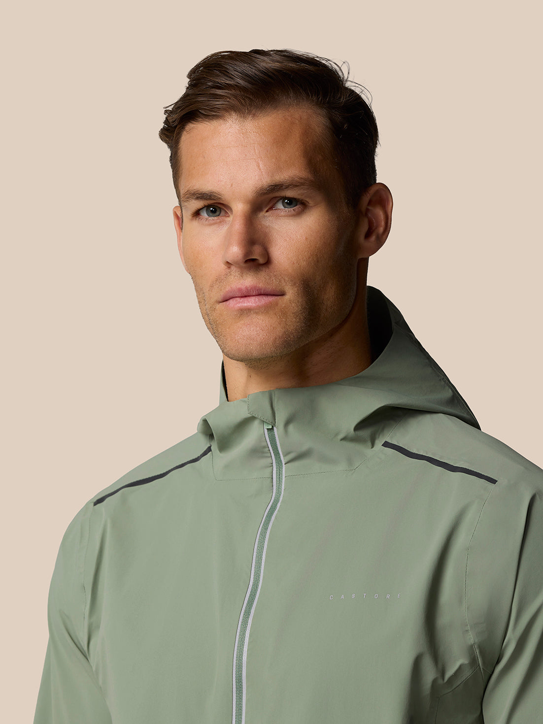 Male model wearing Zone Training LVS Jacket Thyme with front zipper, close up portrait.
