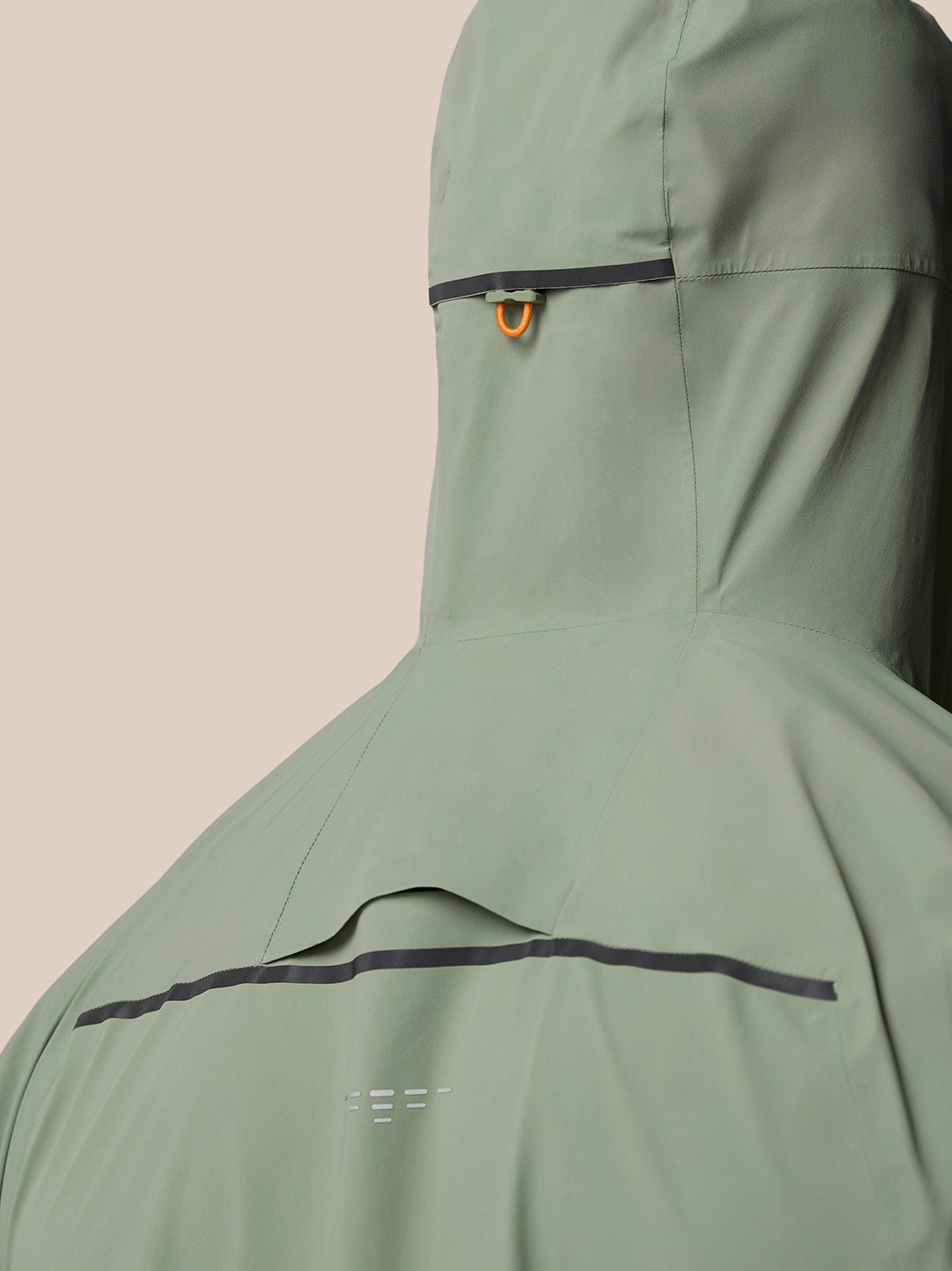 Back view of Zone Training LVS Jacket in Thyme with hood and orange loop, highlighting back ventilation identifier
