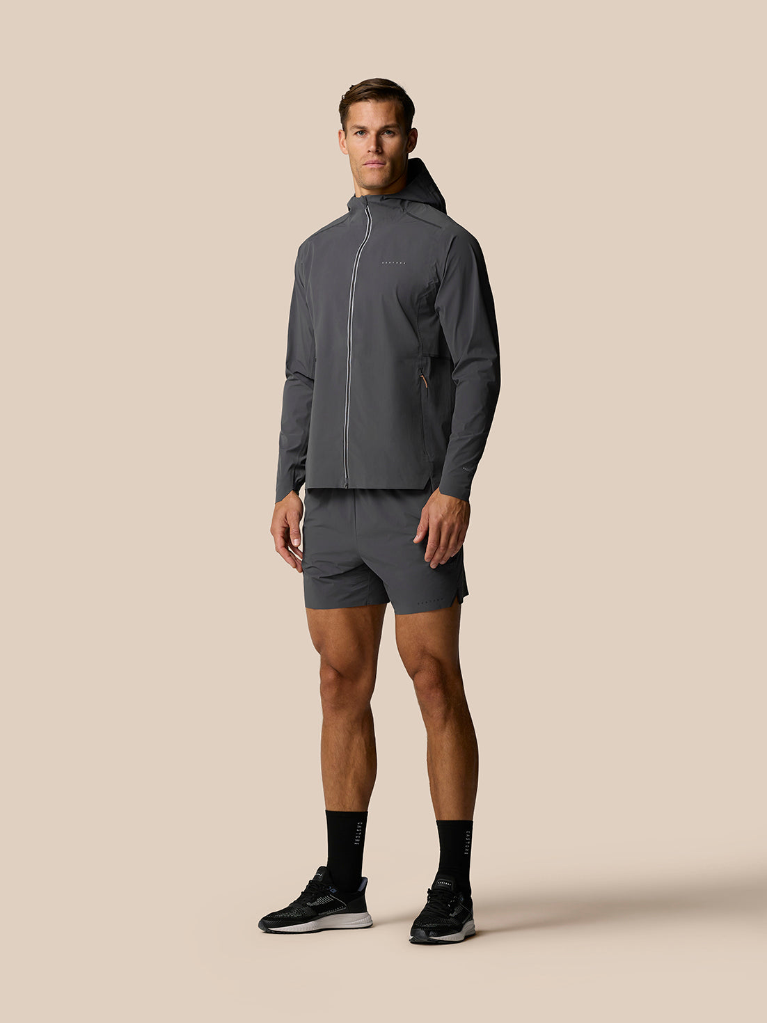Male model in Zone Training LVS Jacket in gunmetal gray with hood down front view