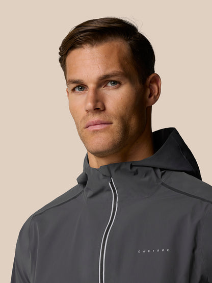 Close up of a male model wearing Zone Training LVS Jacket in gunmetal gray with hood and reflective trim