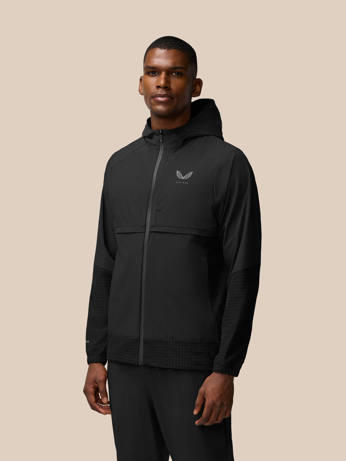 Side profile of a man wearing black Flex Winterised Woven Jacket with hood and front zipper