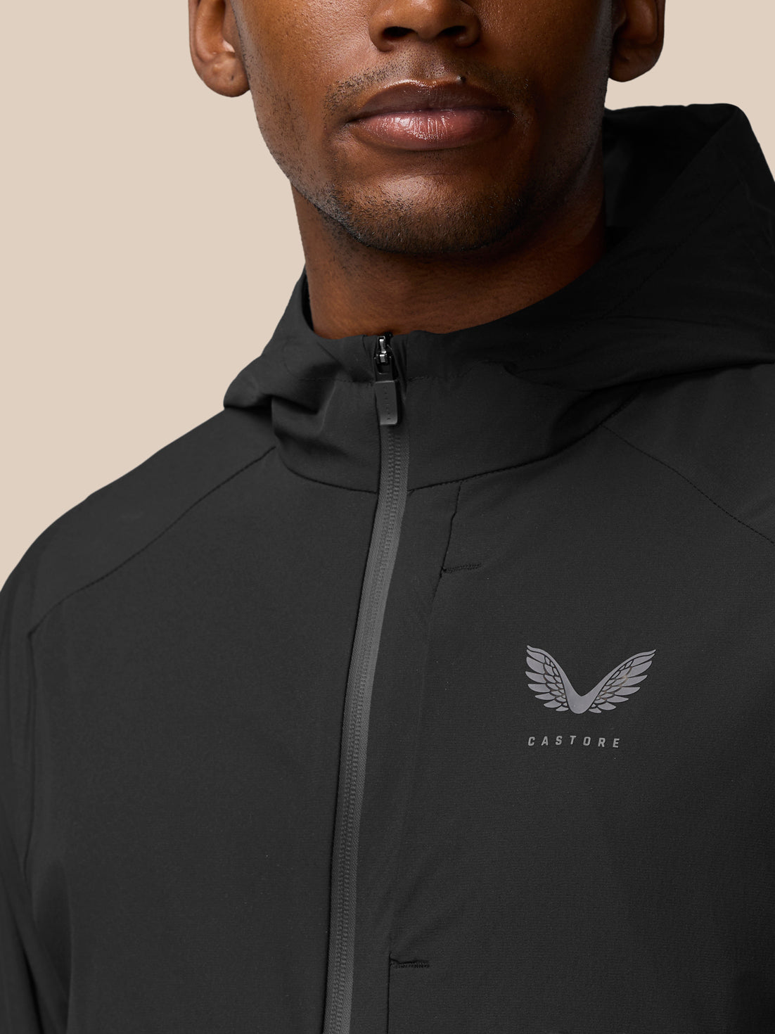 Close-up of the black Flex Winterised Woven Jacket zipper with Castore logo on the chest.