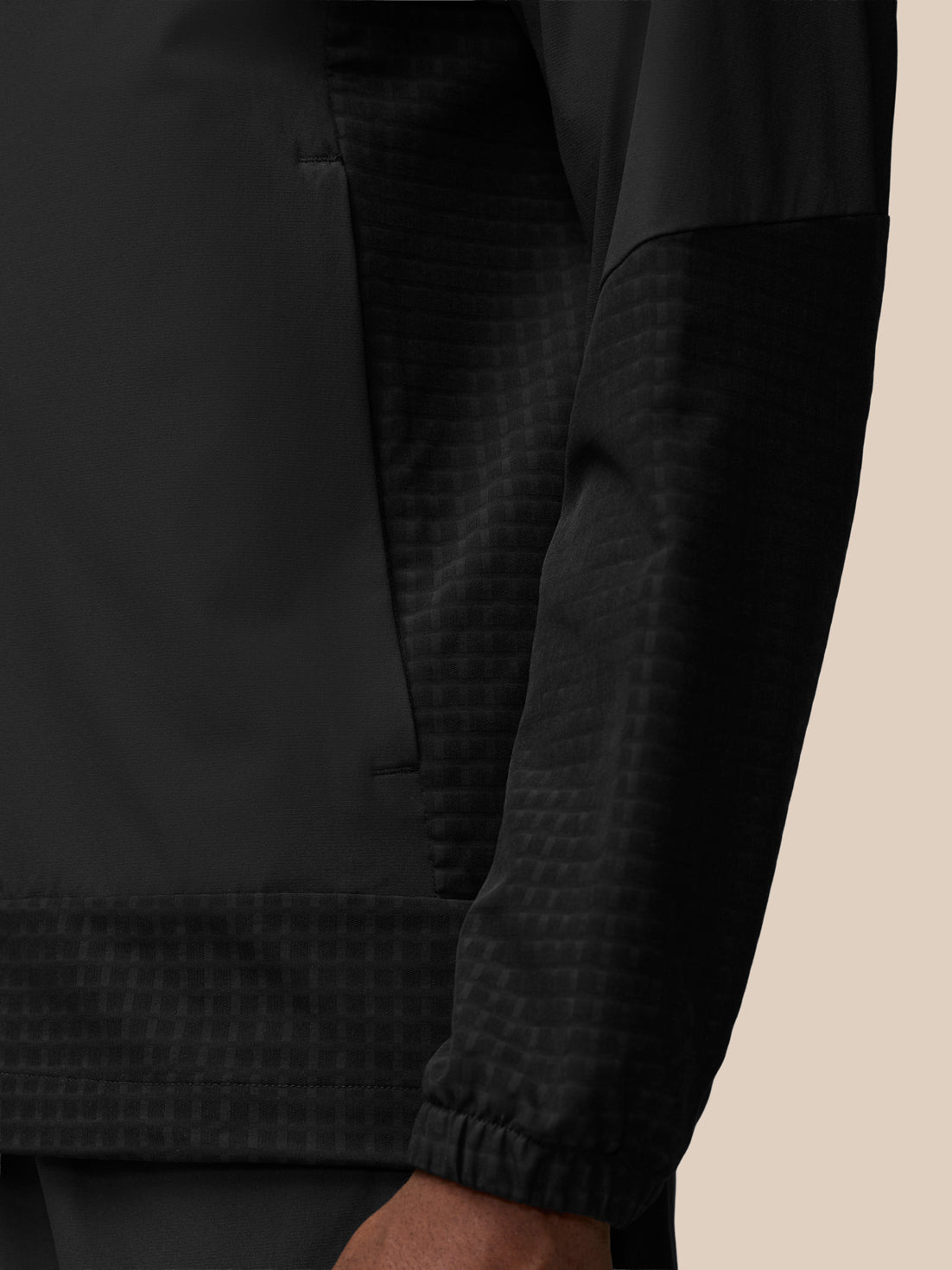Close-up of black Flex Winterised Woven Jacket chest area with zipper and subtle Castore logo
