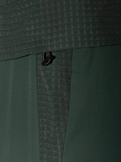 Zipper pull on dark green Flex Winterised Woven Jacket with grid textured fabric.