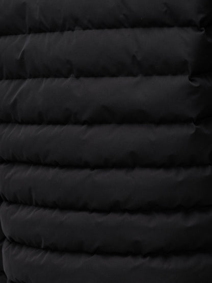 Close up of black quilted exterior from a men's lightweight puffer jacket.