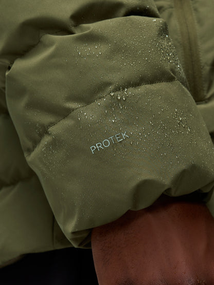 Close-up of olive green lightweight jacket fabric with water droplets and ProTek branding on the sleeve