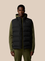 Male model wearing black sleeveless puffer gilet over olive green hoodie.