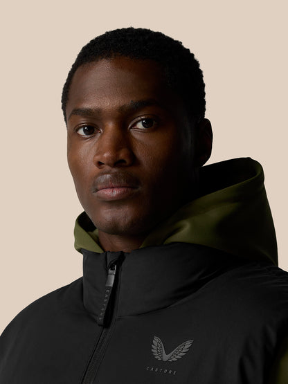 Close-up of male model in black puffer gilet with hooded collar and chest logo