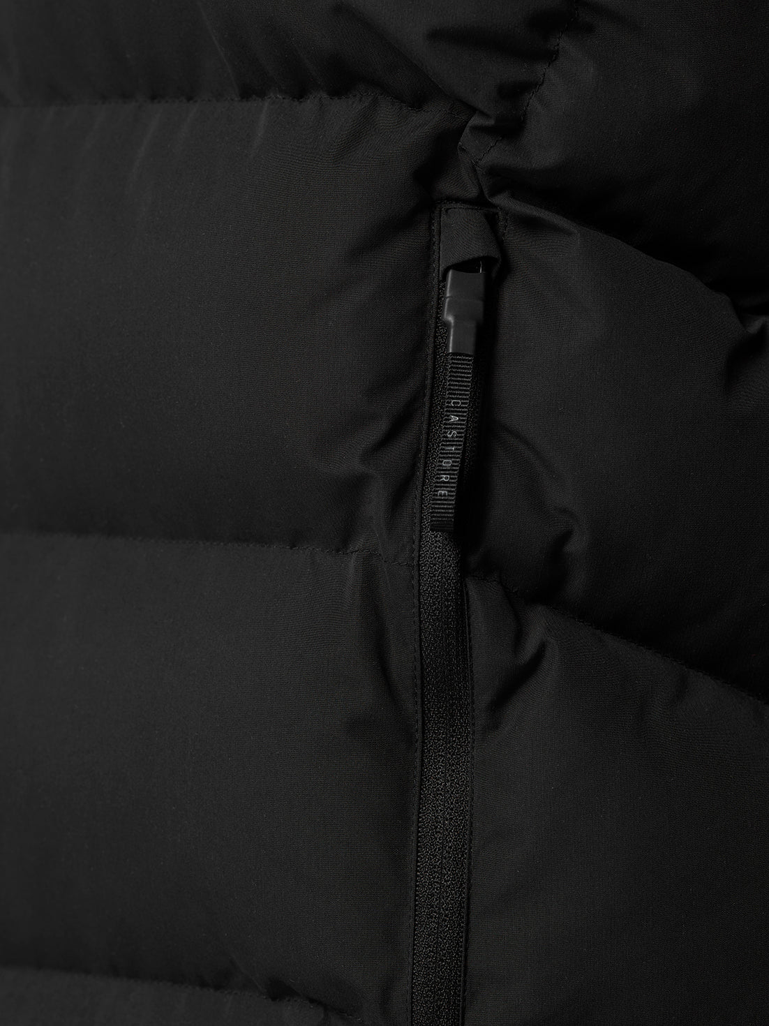 Close up of black puffer vest zipper with ProTek branding