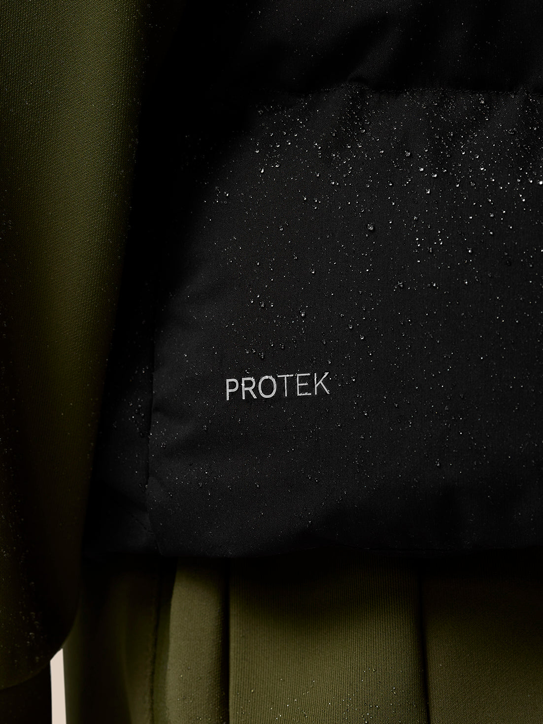 Close up of black ProTek fabric with water droplets on the gilet's surface