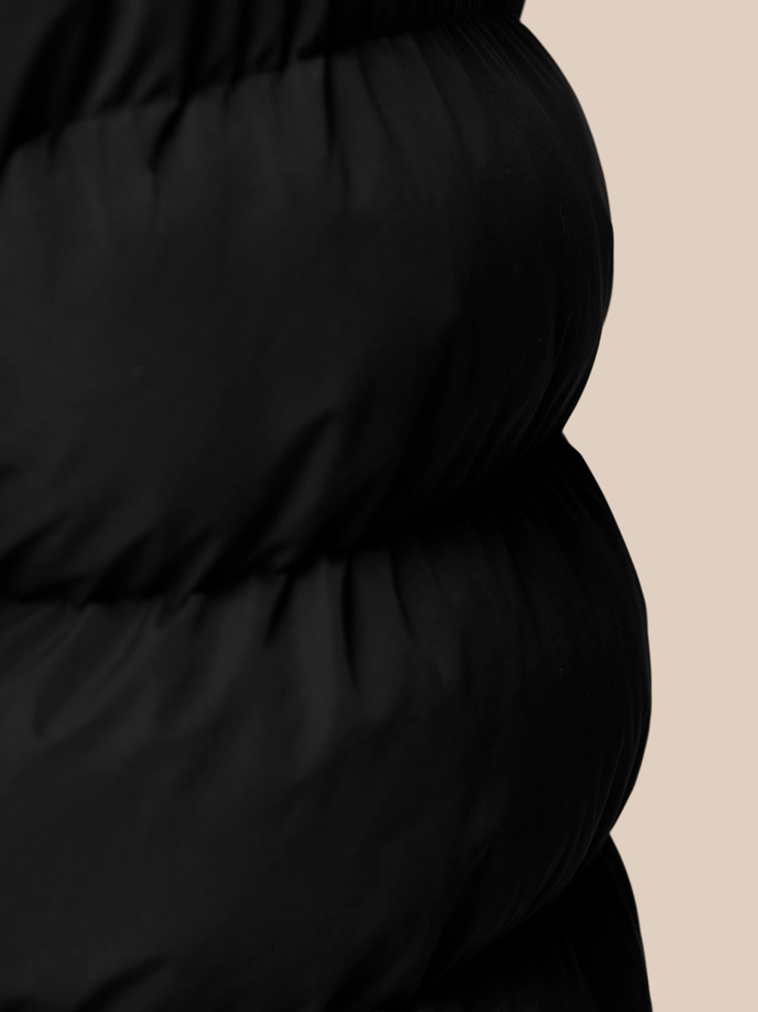 Close up of black quilted fabric from the Puffer Gilet showing horizontal stitching