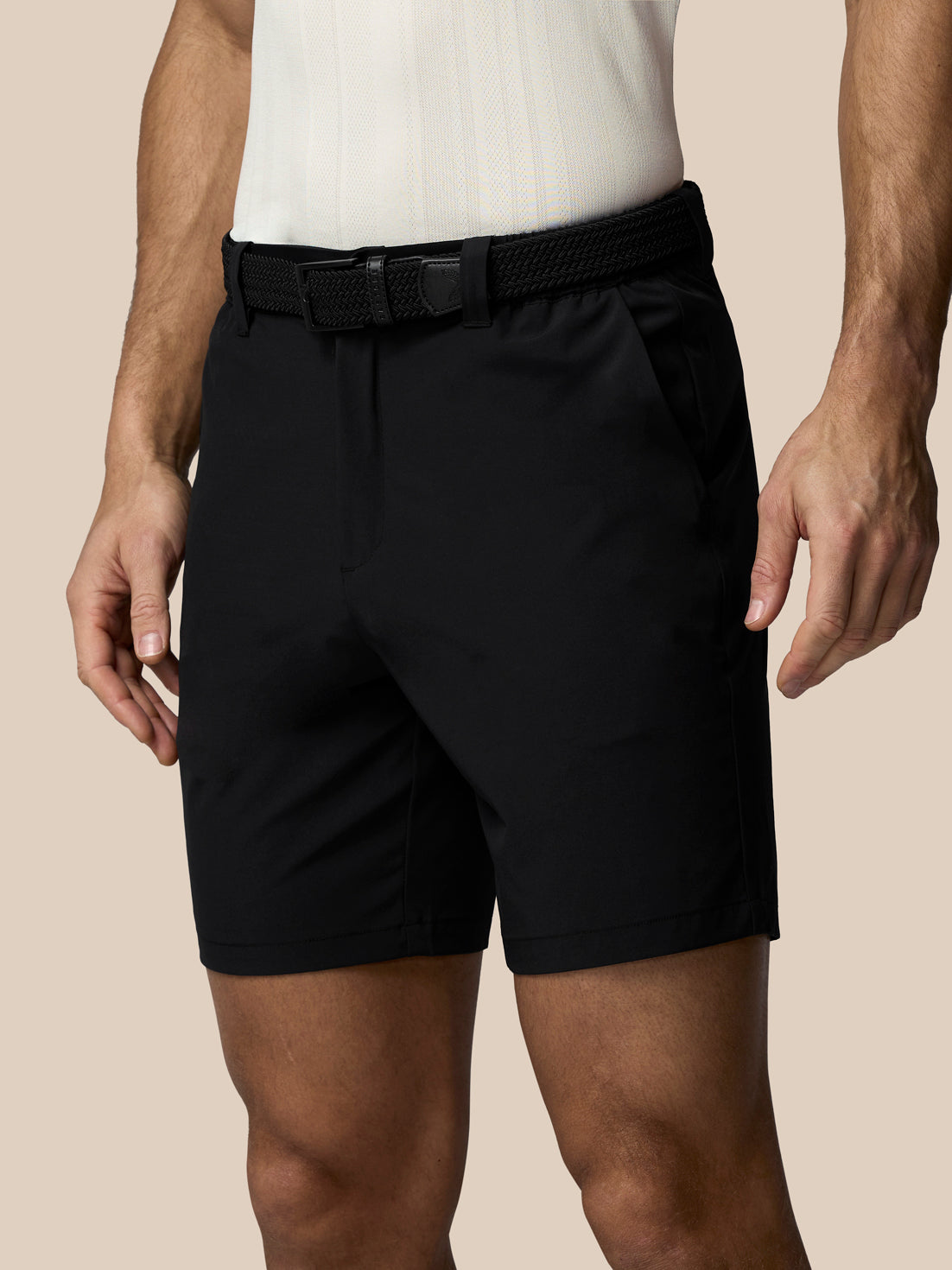 Front view of black Castore x Paul Smith golf shorts with braided belt on a model