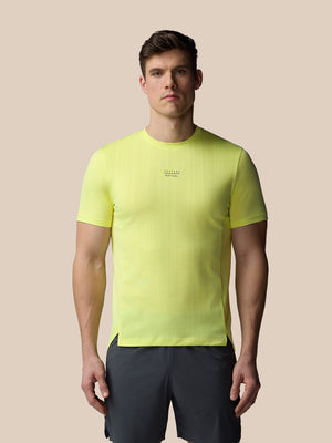 Male model wearing lime neon Castore x Paul Smith Performance Engineered Knit Short Sleeve T Shirt with chest branding
