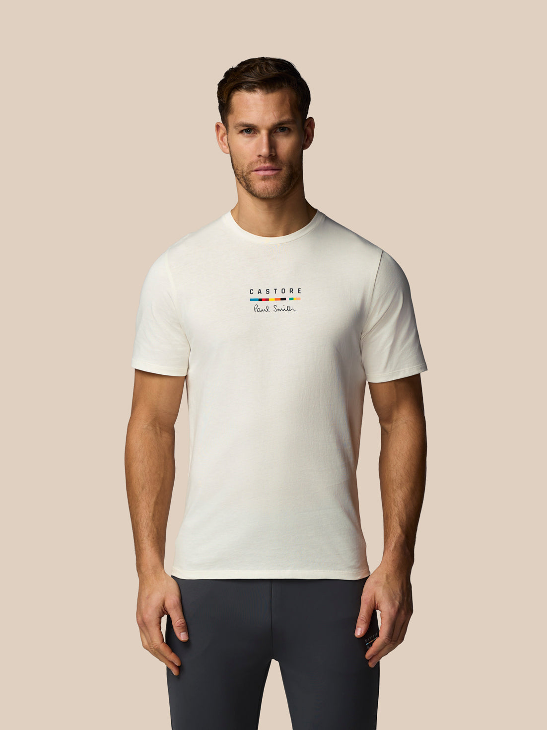 Man wearing a white t-shirt with a logo on a beige background