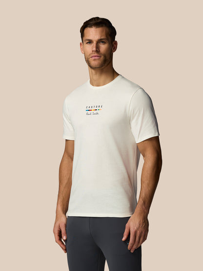 Man wearing a white t-shirt with colorful text on a beige background