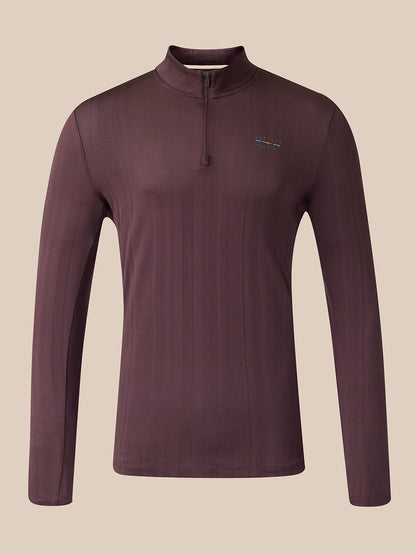 A long-sleeve quarter-zip athletic top shown from the front, in a dark plum-brown color with a small vertical multicolor logo near the upper back, set against a solid beige background.