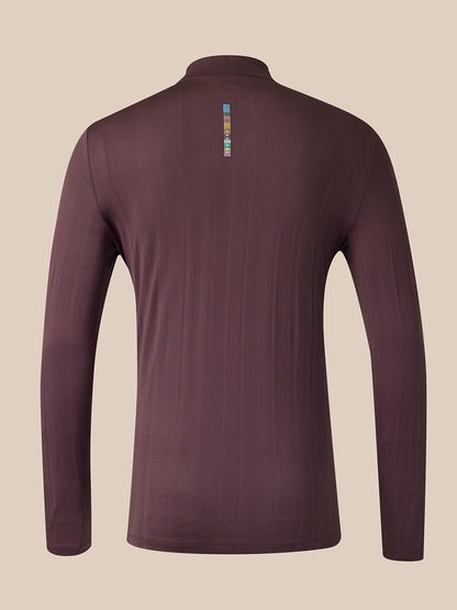 A long-sleeve quarter-zip athletic top shown from the back, in a dark plum-brown color with a small vertical multicolor logo near the upper back, set against a solid beige background.