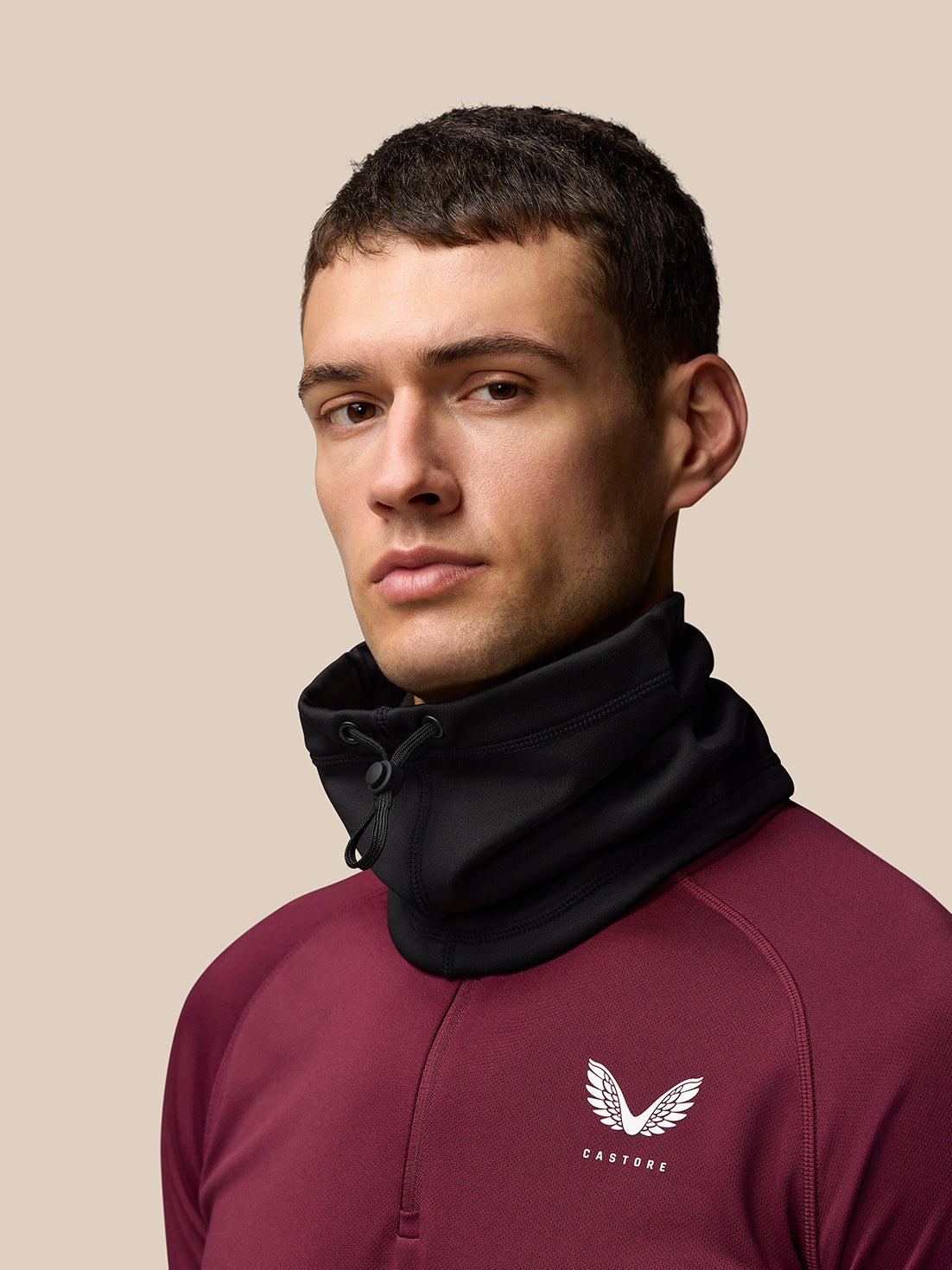 Male model wearing a black snood around the neck with a high collar.