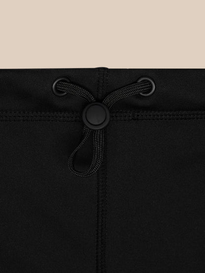 Close-up of black snood drawstring closure with a round plastic toggle and grommets.