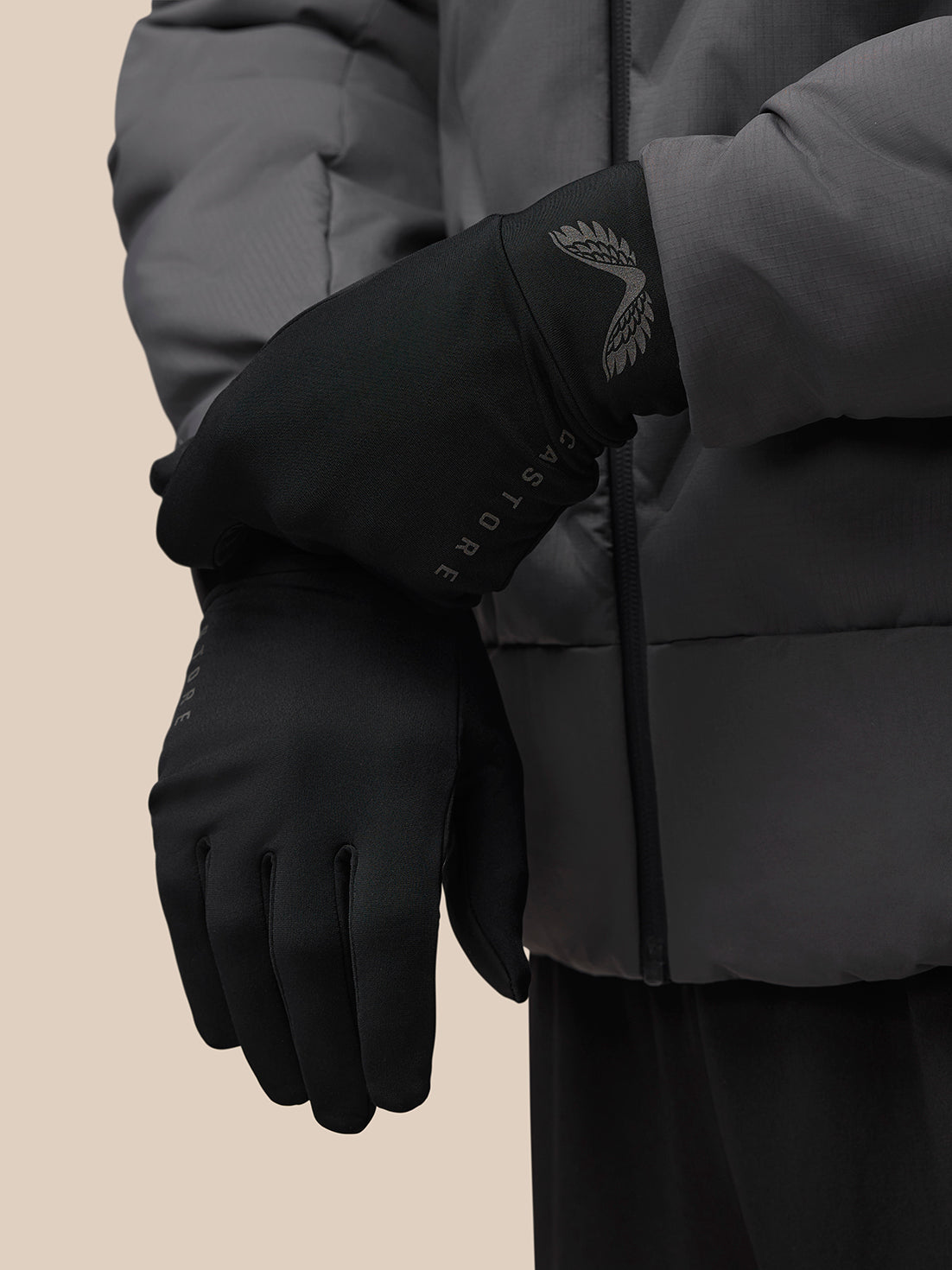 Close up of a black Castore glove with reflective wing logo and Castore word mark on the wrist