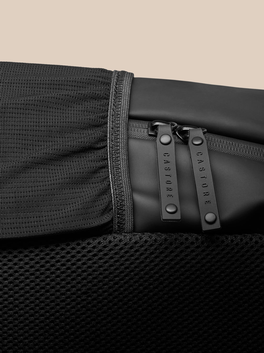 Close up of zipper pulls on the black Active Backpack with CASTORE branding and textured fabric.