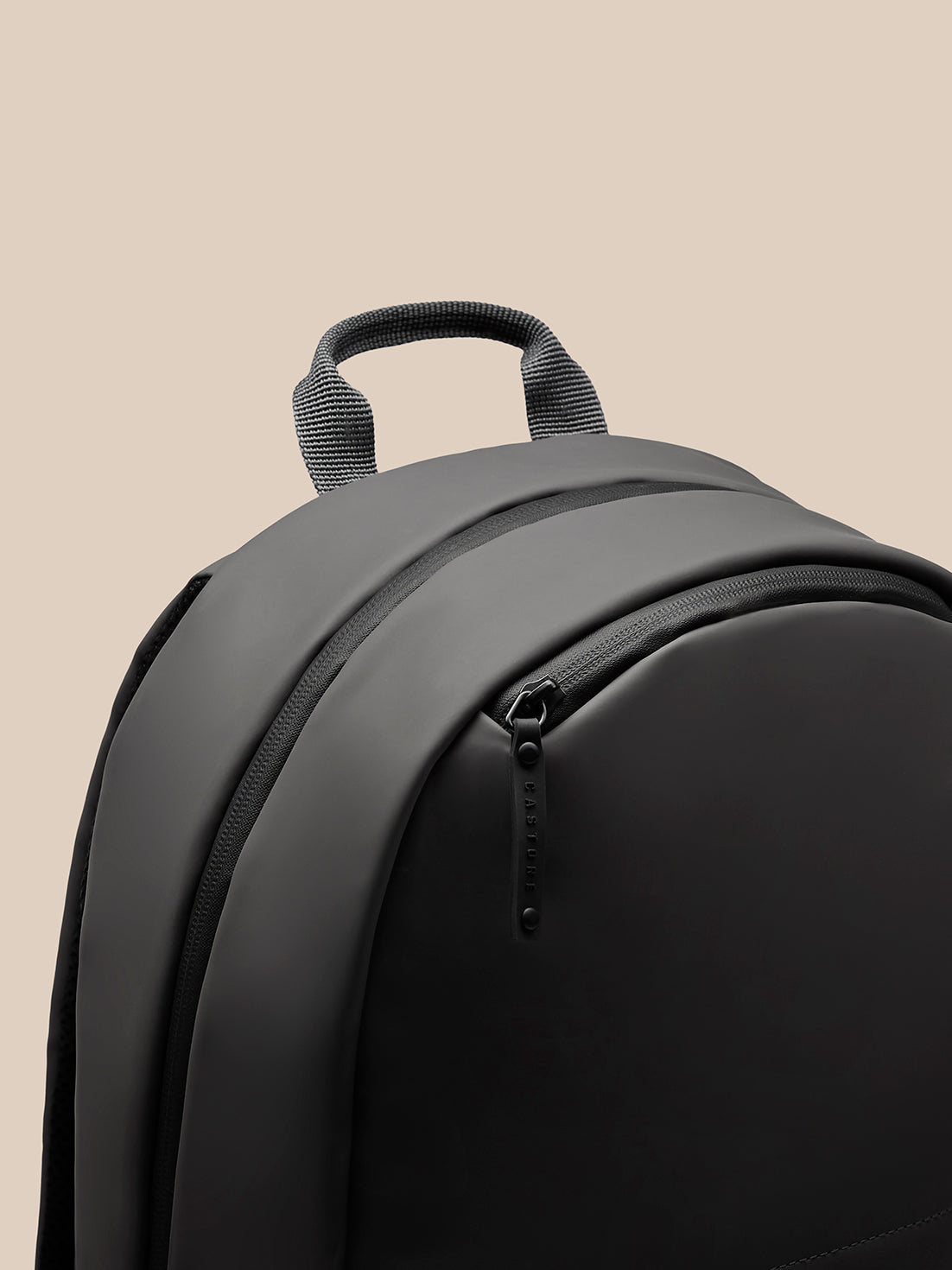 Close up of charcoal backpack back with padded straps and top carrying loop