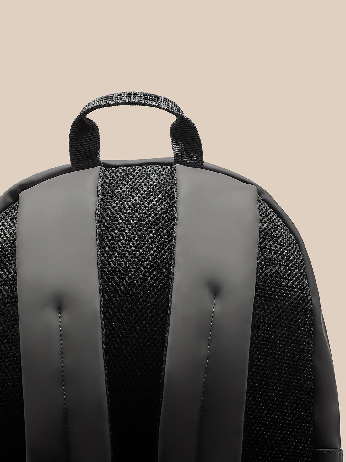 Top edge of charcoal backpack with handle and central zipper