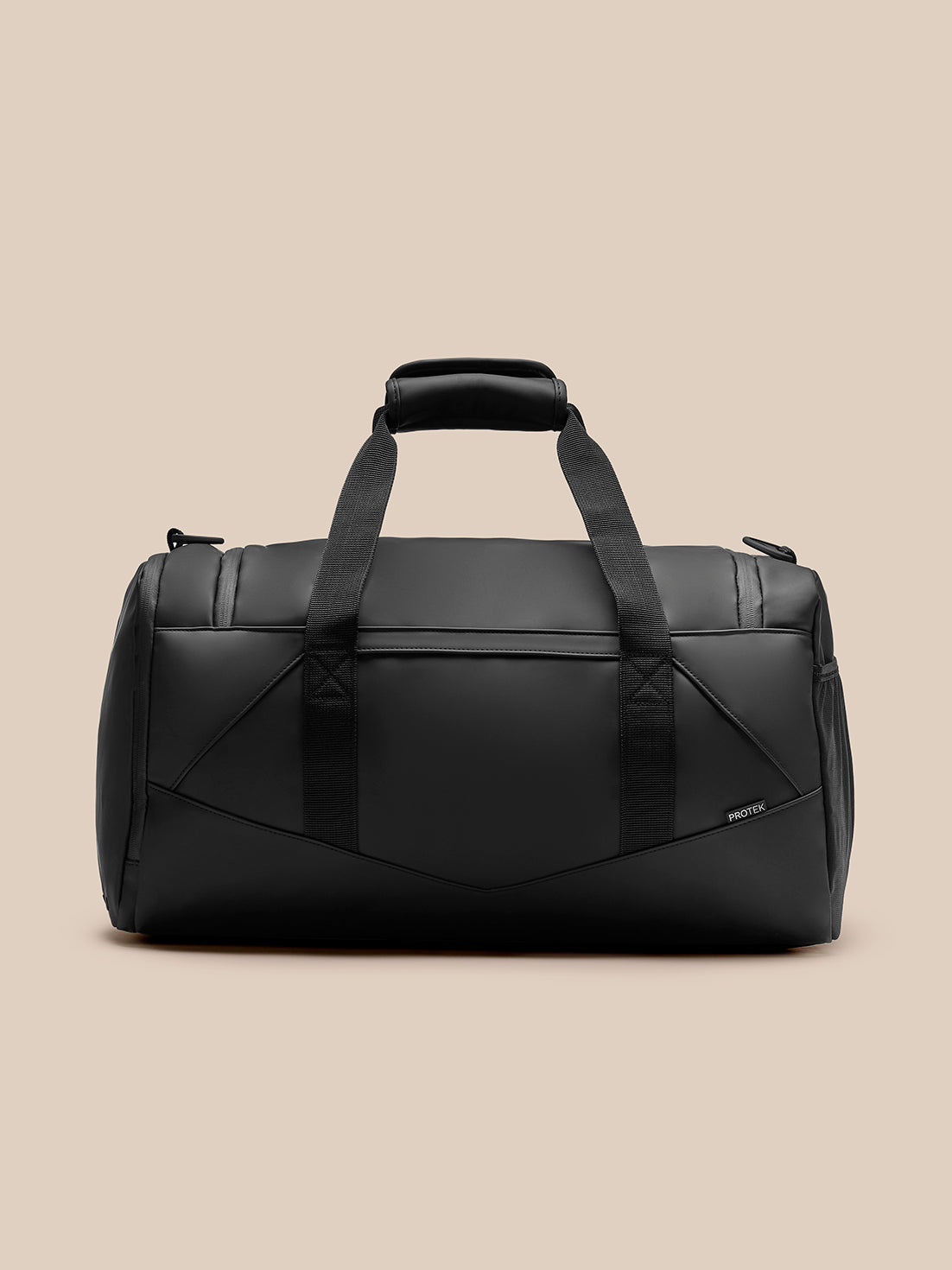 Black travel holdall with padded top handle and two wide straps shown against a beige background