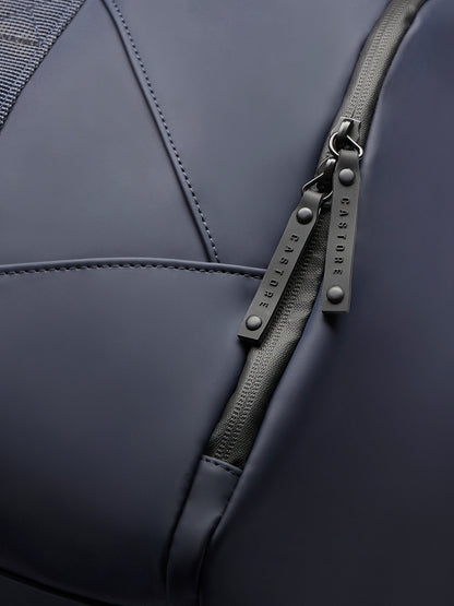 Detailed view of navy holdall zipper with double pulls and branded hardware on smooth fabric