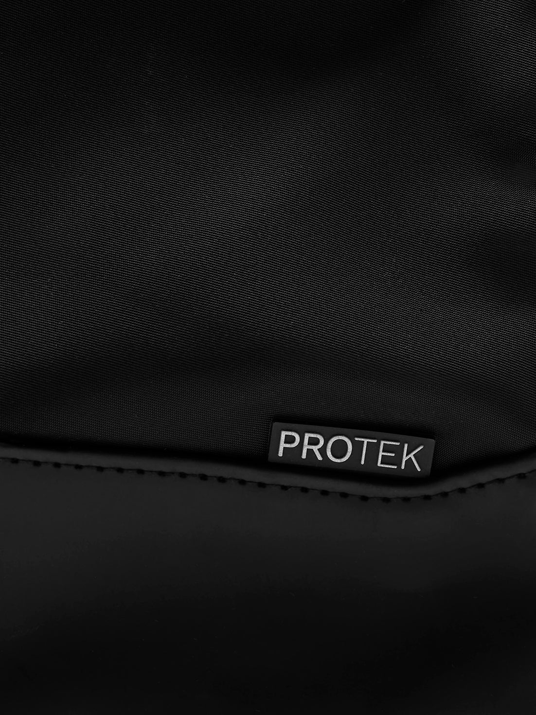 Close-up of ProTek label on the black Pursuit backpack fabric.
