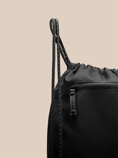Close-up of black Active Training Gymsack showing drawstring top and front zipper pocket with Castore branded pull