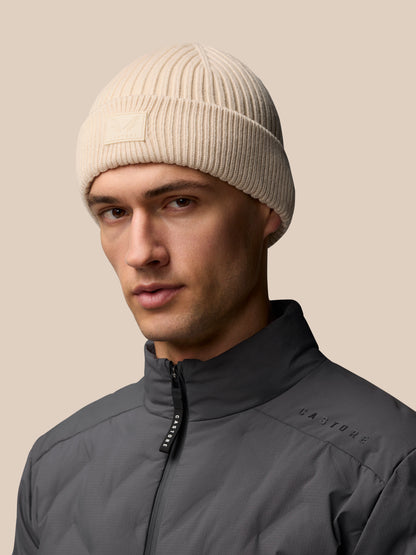 Stone colored ribbed knit Active Beanie with foldover Castore logo patch worn by a model.