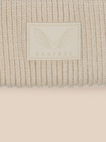 Close up of cuff showing Castore label with wings on beige knit
