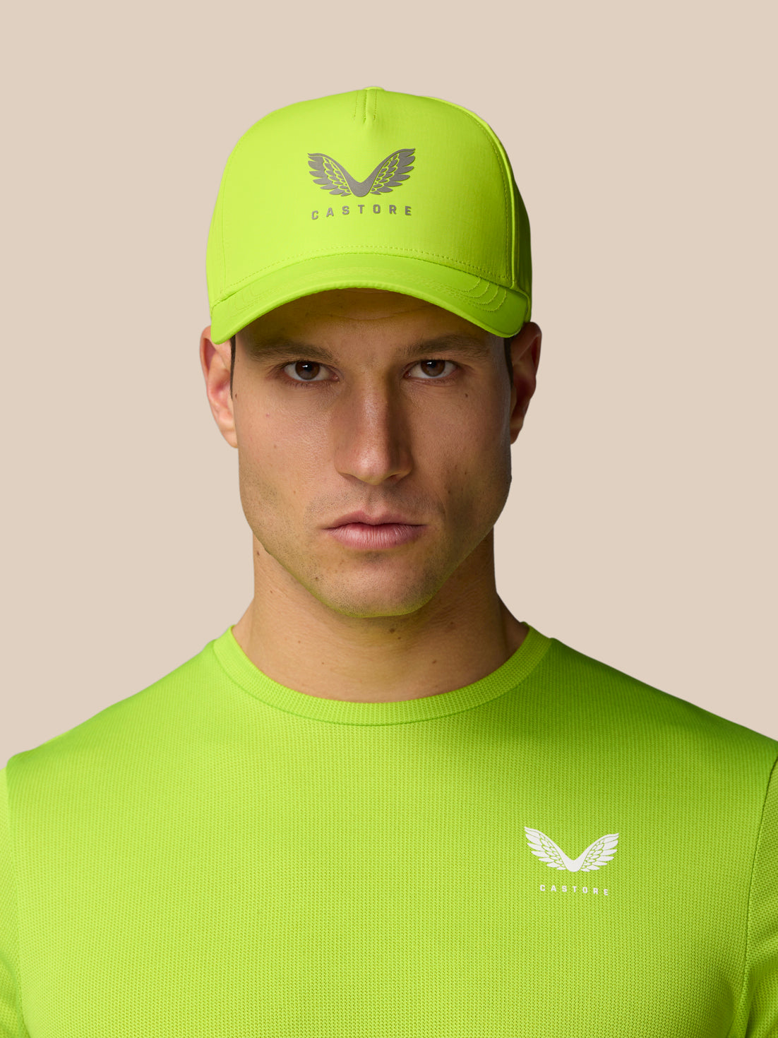 Model wearing neon lime Active Logo Cap with Castore branding on the front.