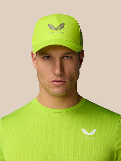 Model wearing neon lime Active Logo Cap with Castore branding on the front.