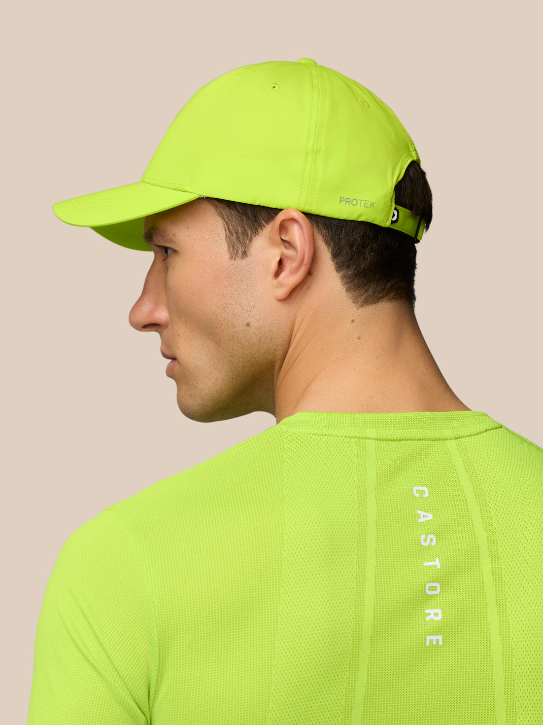 Side profile of a man wearing a neon lime Active Cap with adjustable back strap