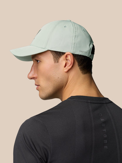 Side profile of a man wearing a sage Active Cap with adjustable back strap and halo eyelets