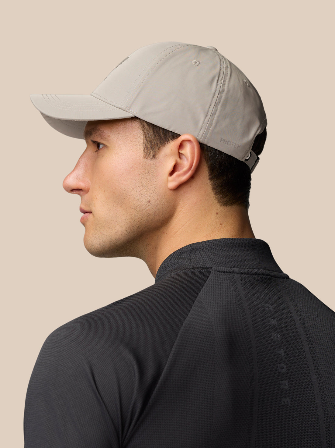 Side profile of a model wearing a light grey Active Cap with an adjustable back strap