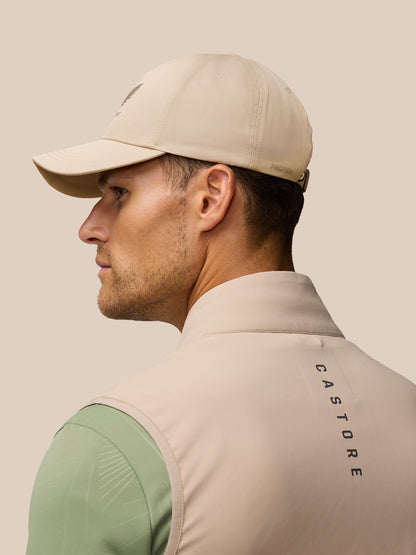 Profile view of a man wearing a mushroom beige cap with an adjustable back strap