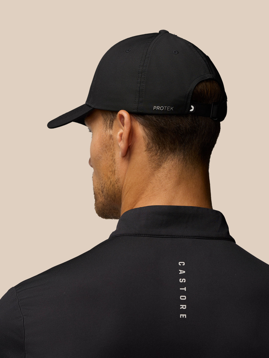 Back view of black Castore Cap with adjustable strap and subtle branding
