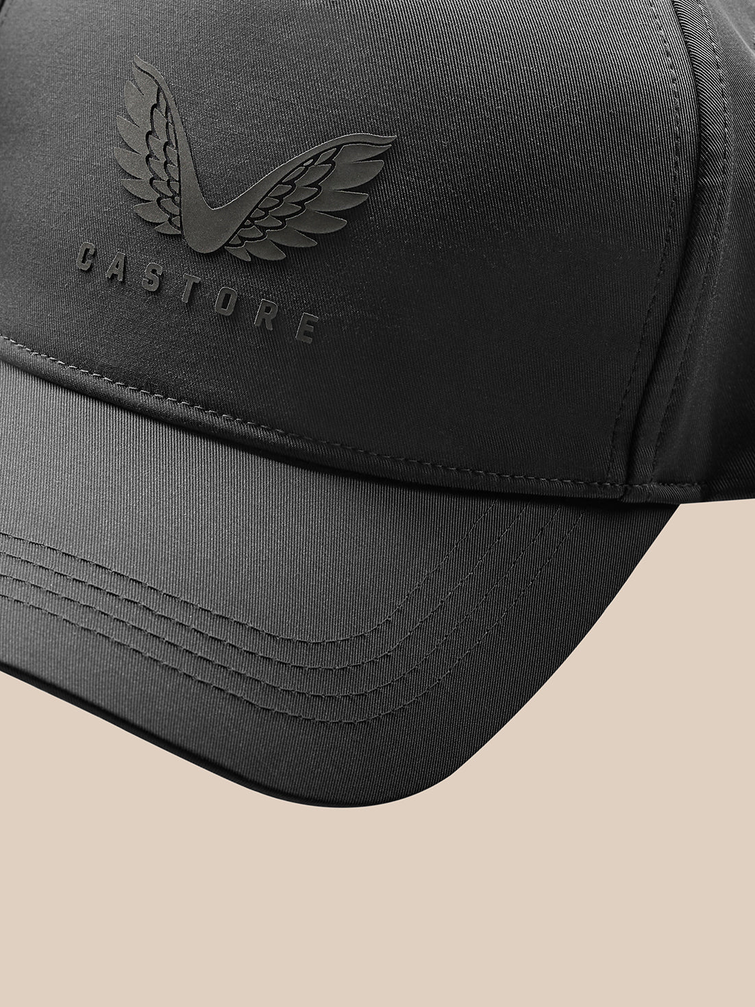 Close up of the charcoal cap highlighting the embossed Castore wings logo and branding