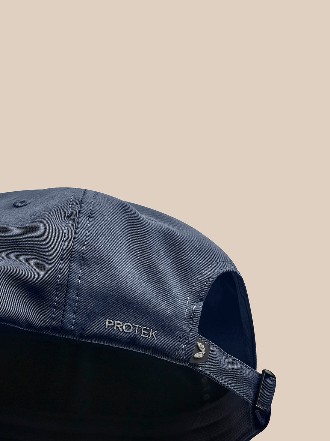 Navy cap close up showing PROTEK branding along the side and curved brim